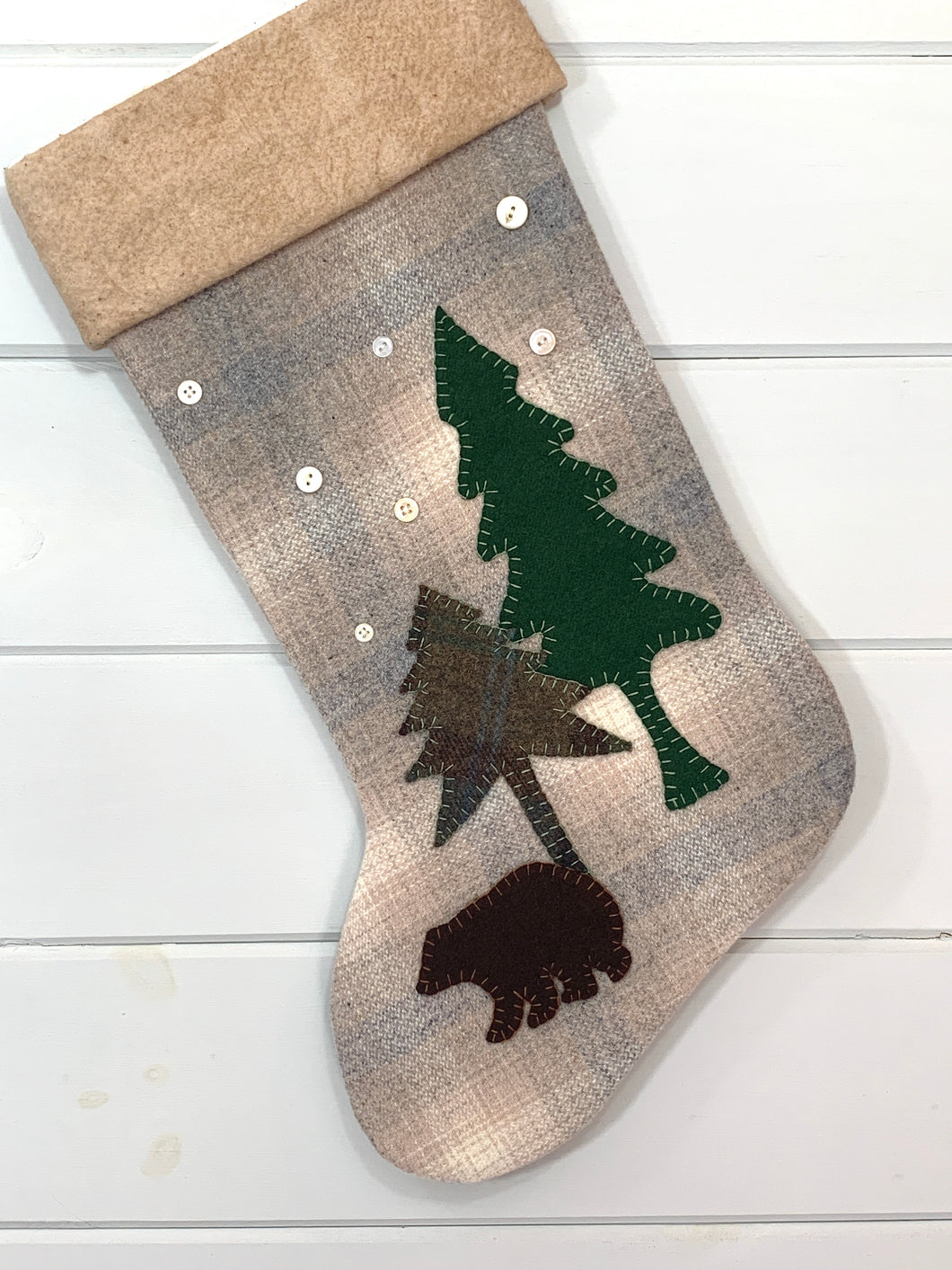 bear Christmas stocking, cream, tan, light blue plaid wool fabric Christmas stocking, brown bear is brown wool fabric, tall pine tree is green wool fabric, short pine tree is green plaid wool fabric, trees and bear are hand stitched to stocking, seven white vintage buttons sewn onto stocking for snowflakes, cuff is tea dyed cotton batting, woodland brown bear Christmas stocking, rustic bear Christmas stocking, large stocking