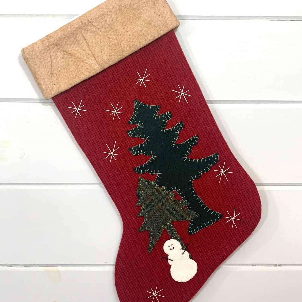 snowman Christmas stocking, little snowman Christmas stocking, red tweed wool fabric stocking, snowman is white wool fabric with black stitched eyes, mouth, arms, two pine trees, one tall pine tree is dark green wool fabric, short pine tree is green blue plaid wool fabric, snowman and pine trees are stitched onto stocking, white snowflakes are hand stitched onto stocking, cuff is tea dyed cotton batting, woodland stocking, rustic Christmas, large stocking